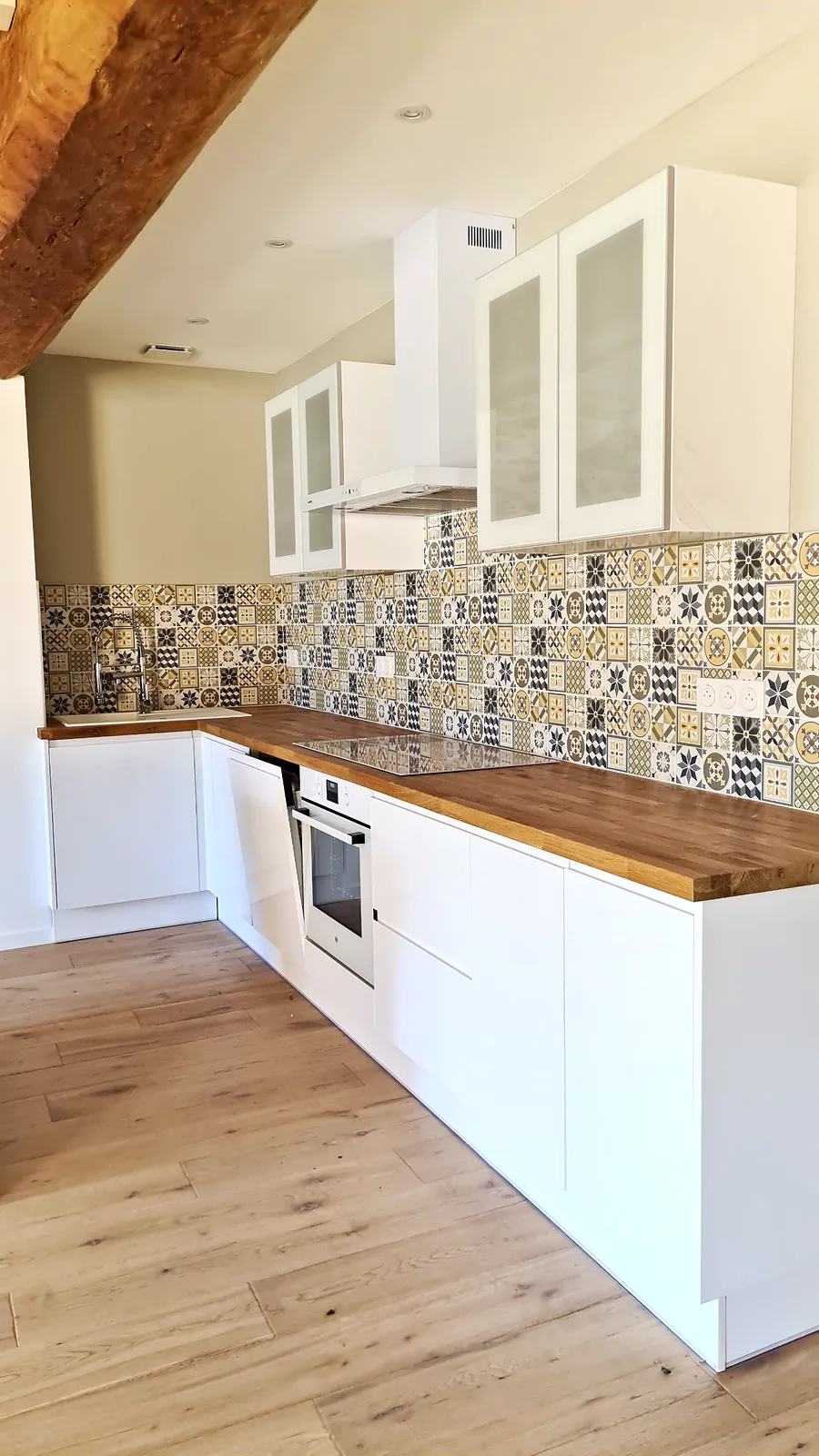 Cuisine équipée : four, plaque de cuisson, hotte et crédence à motifs