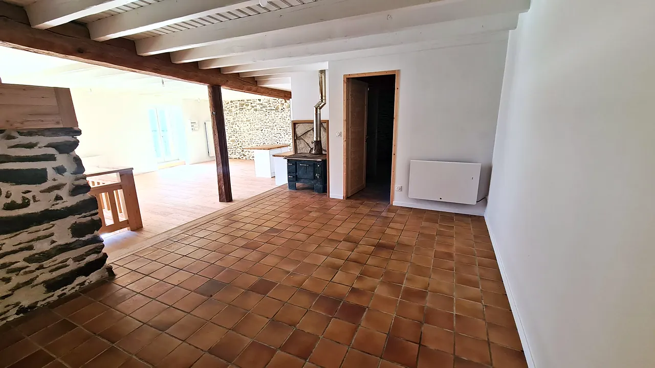 Espace repas en tomettes autour de la cuisinière à bois