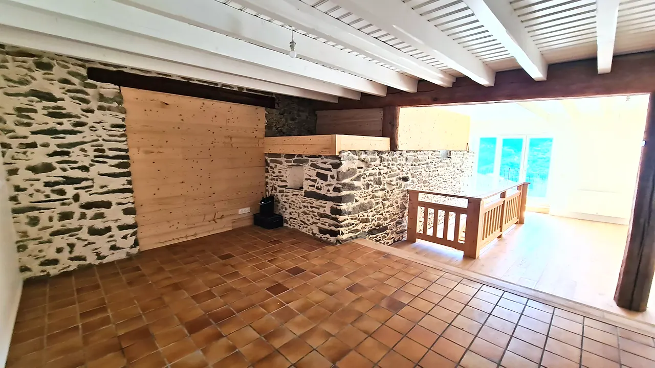 Mur en pierre apparente, tomettes et solives blanchies